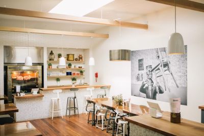 Souvla rotisserie, communal table, and photomural. (Photo by Jessica Mericle.)