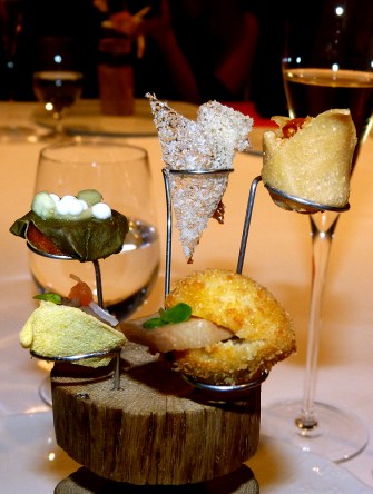 A group of appetizers that represent international dishes that have impressed Joan Roca and his brothers. The tastes were from Mexico (a miniature burrito with mole poblano and guacamole), Peru (ceviche broth), China (pickled vegetables with plum cream), Morocco (goat yogurt with almond slivers, honey, saffron, ras el hanout, and rose petals), and from Korea (panco fried bread, bacon with soja sauce, snow peas, kimchi, and sesame oil). (Photo by Manos Angelakis, Epoch Taste)